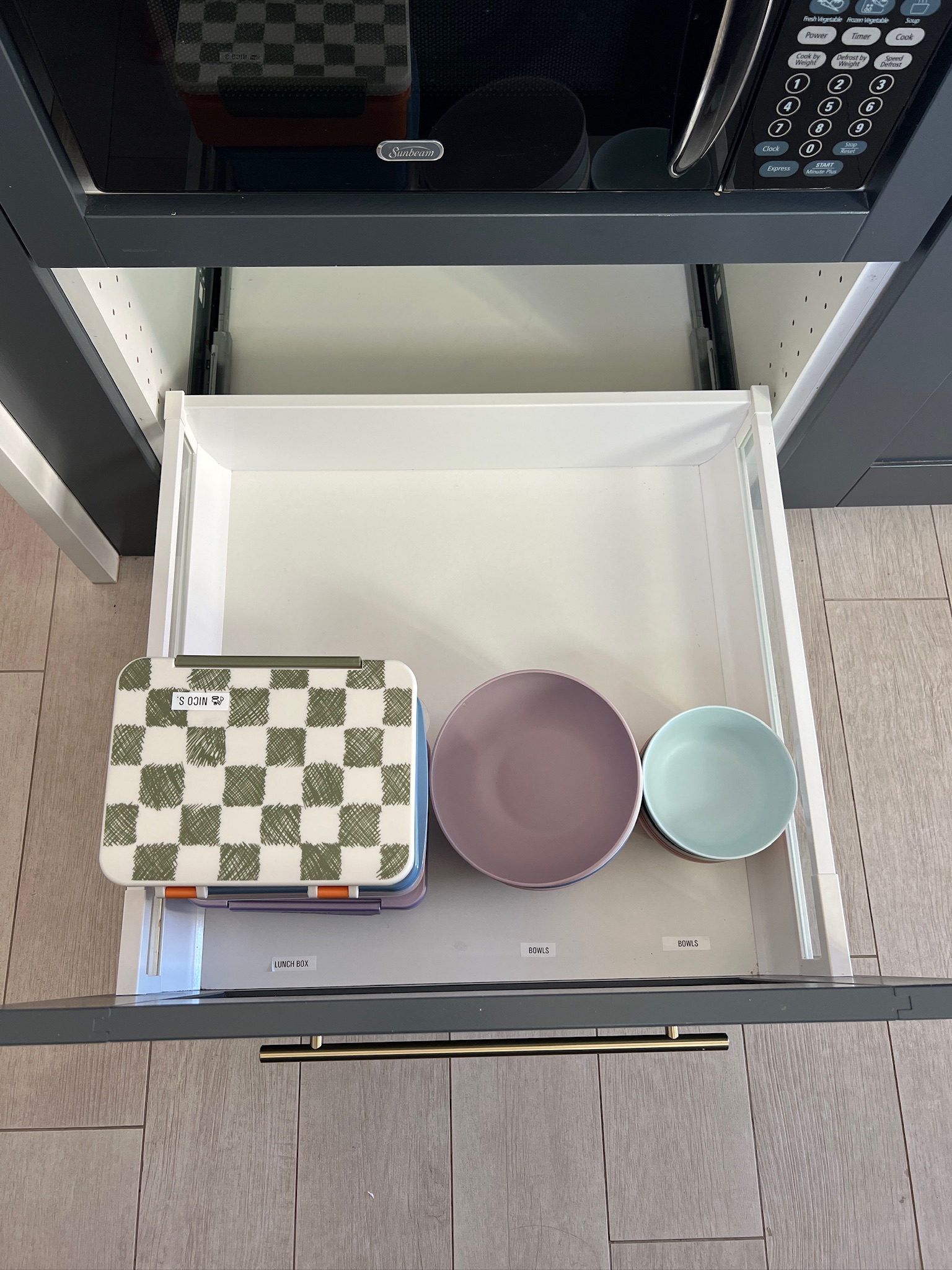 Organized kitchen drawer with labeled sections for spices and cooking essentials.